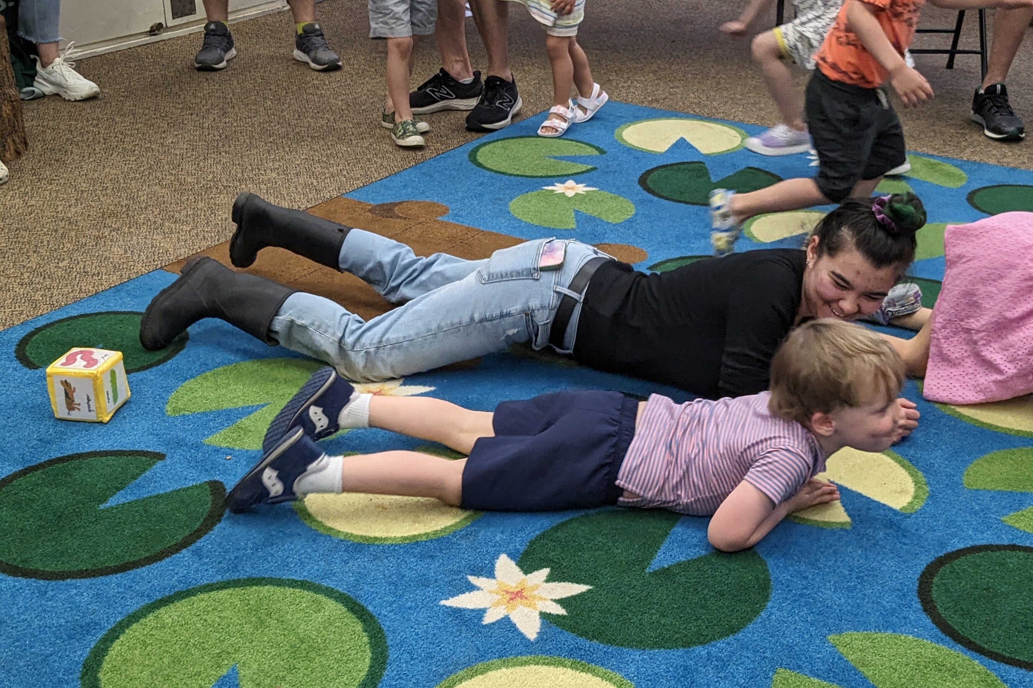 adult and child wiggling on their bellies like a worm